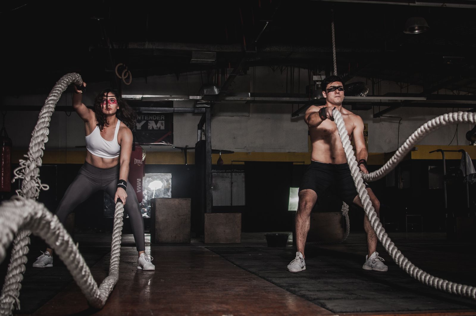 Deux membres en plein exercice de battle ropes dans la salle